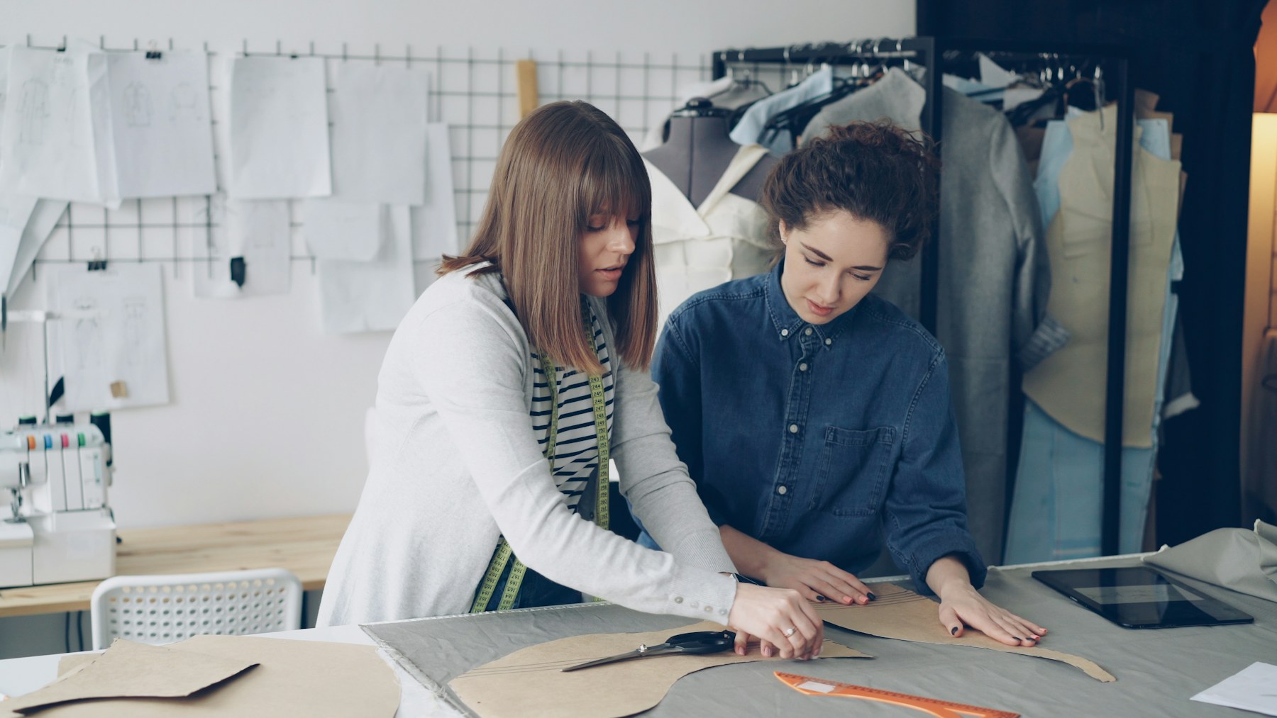 Fashion design team measuring patterns and reviewing fabric together
